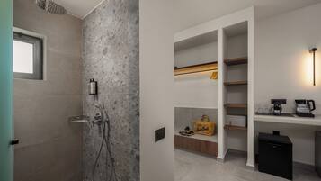A modern bathroom with a shower, built-in shelves, and a coffee machine.