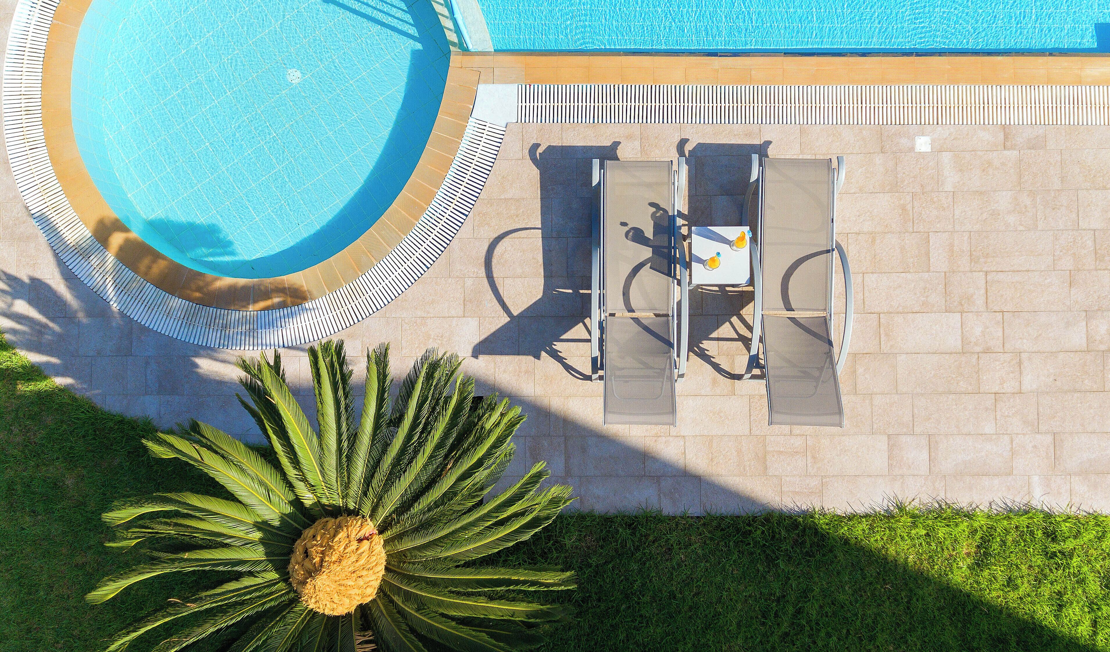 Una piscina al aire libre de temporada, sombrillas, tumbonas