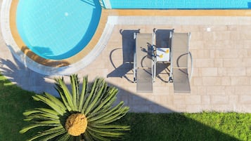 Una piscina al aire libre de temporada, sombrillas, tumbonas