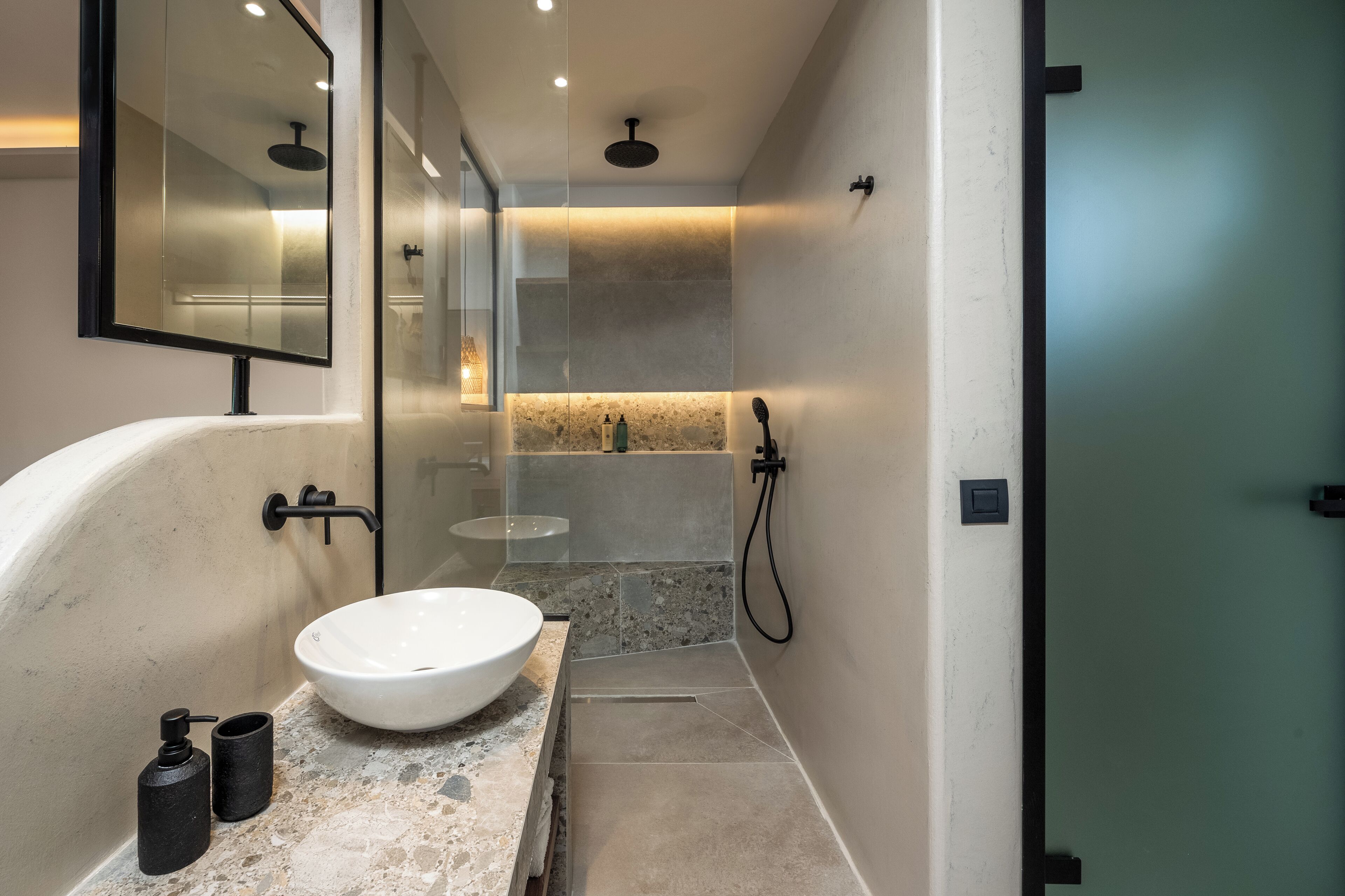 A modern bathroom with a freestanding bathtub, a large mirror, and a glass-enclosed shower area.