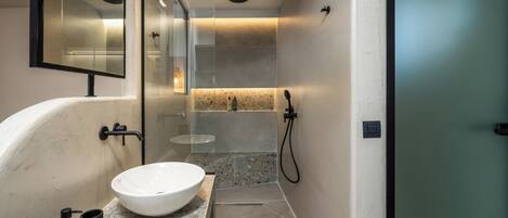 A modern bathroom with a freestanding bathtub, a large mirror, and a glass-enclosed shower area.