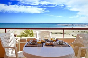 Una mesa lista para el desayuno, con vista a la playa y al océano.