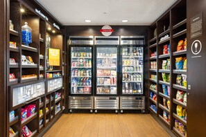Un bar de aperitivos con vitrinas refrigeradas y estanterías llenas de diferentes opciones de comida y bebida.