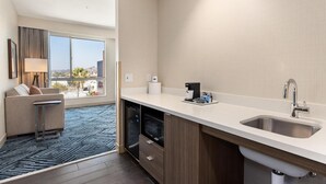 Ett modernt kök med diskmaskin, diskho och ett fönster med utsikt över stadsbilden.