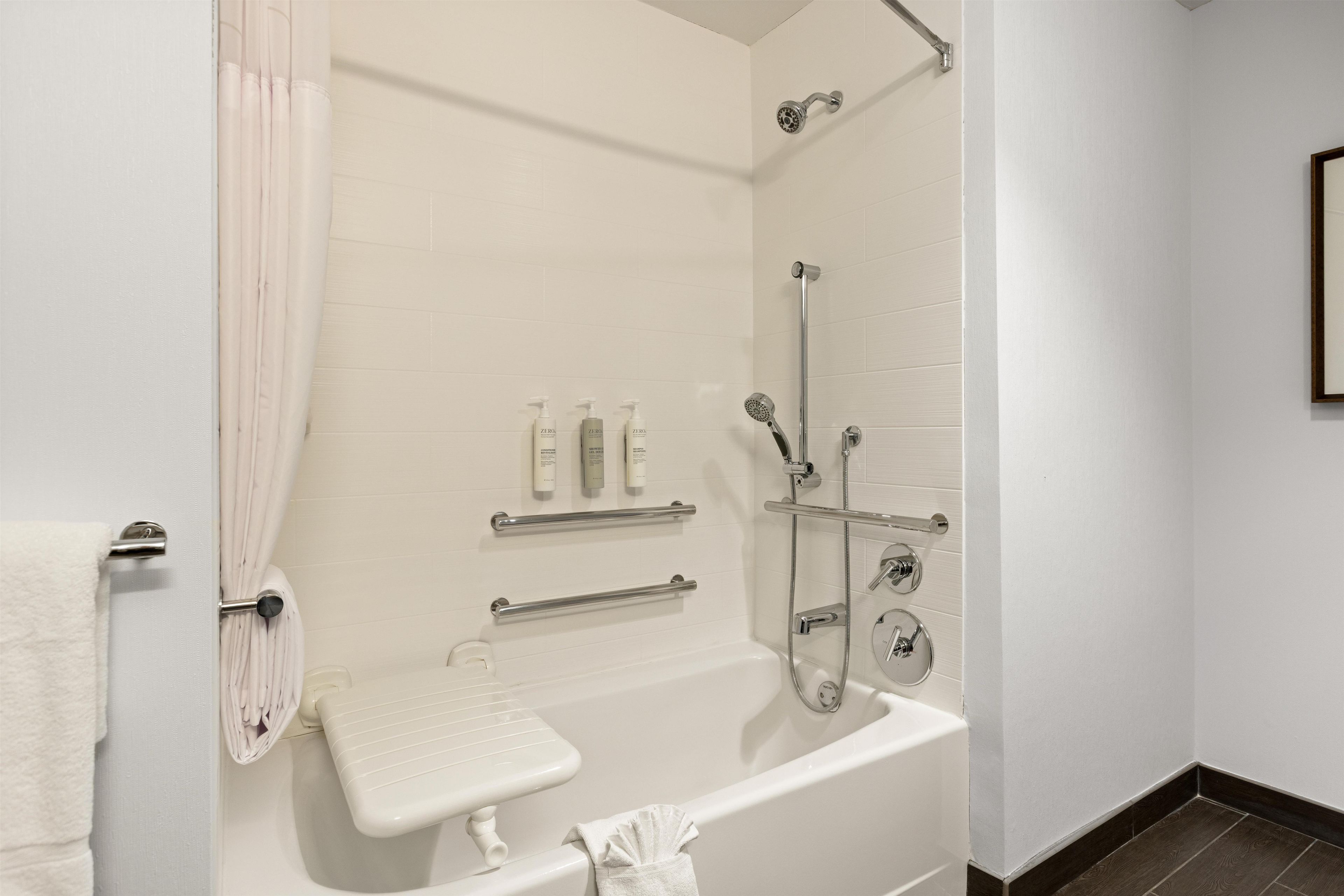 A modern bathroom with a bathtub, shower, and toilet.