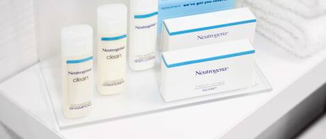Neutrogena products including body lotion, body wash, and shampoo on a white shelf.