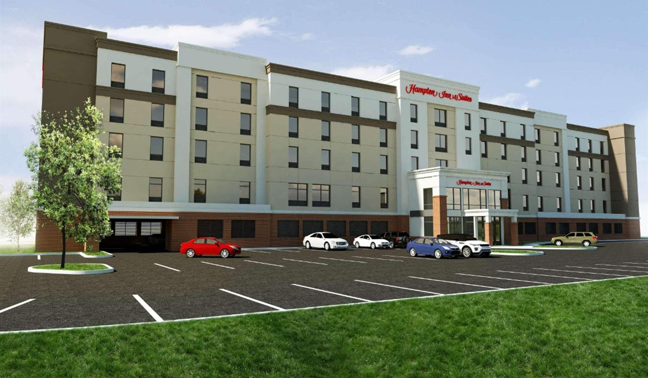 A Hampton Inn & Suites hotel with a parking lot and a tree in front.