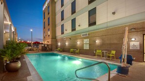A hotel pool area with a pool, chairs, and a pool lift. - Home2 Suites by Hilton Waco (Waco)