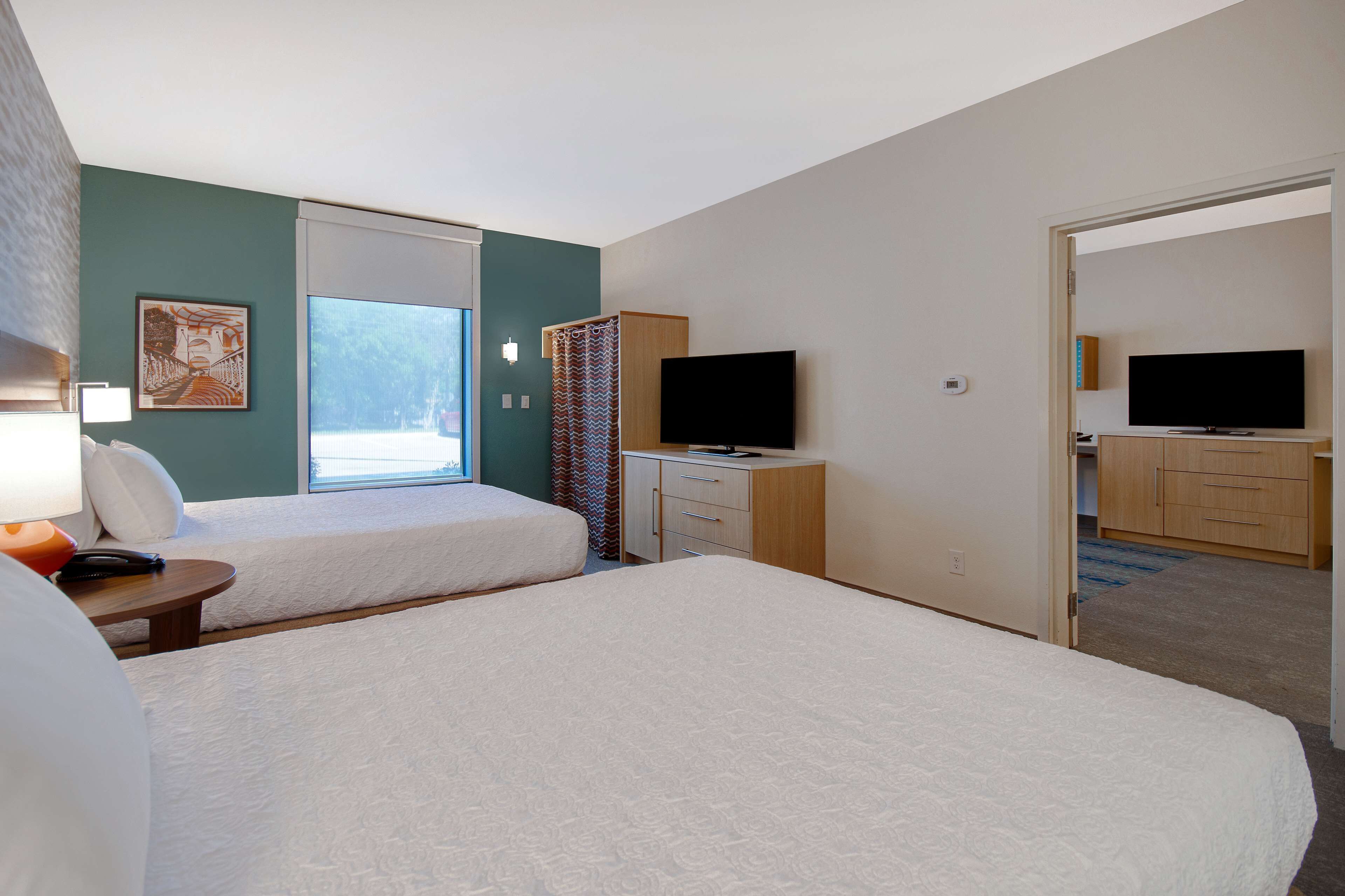 Ett hotellrum med två sängar, en TV, ett skrivbord och ett fönster med utsikt.