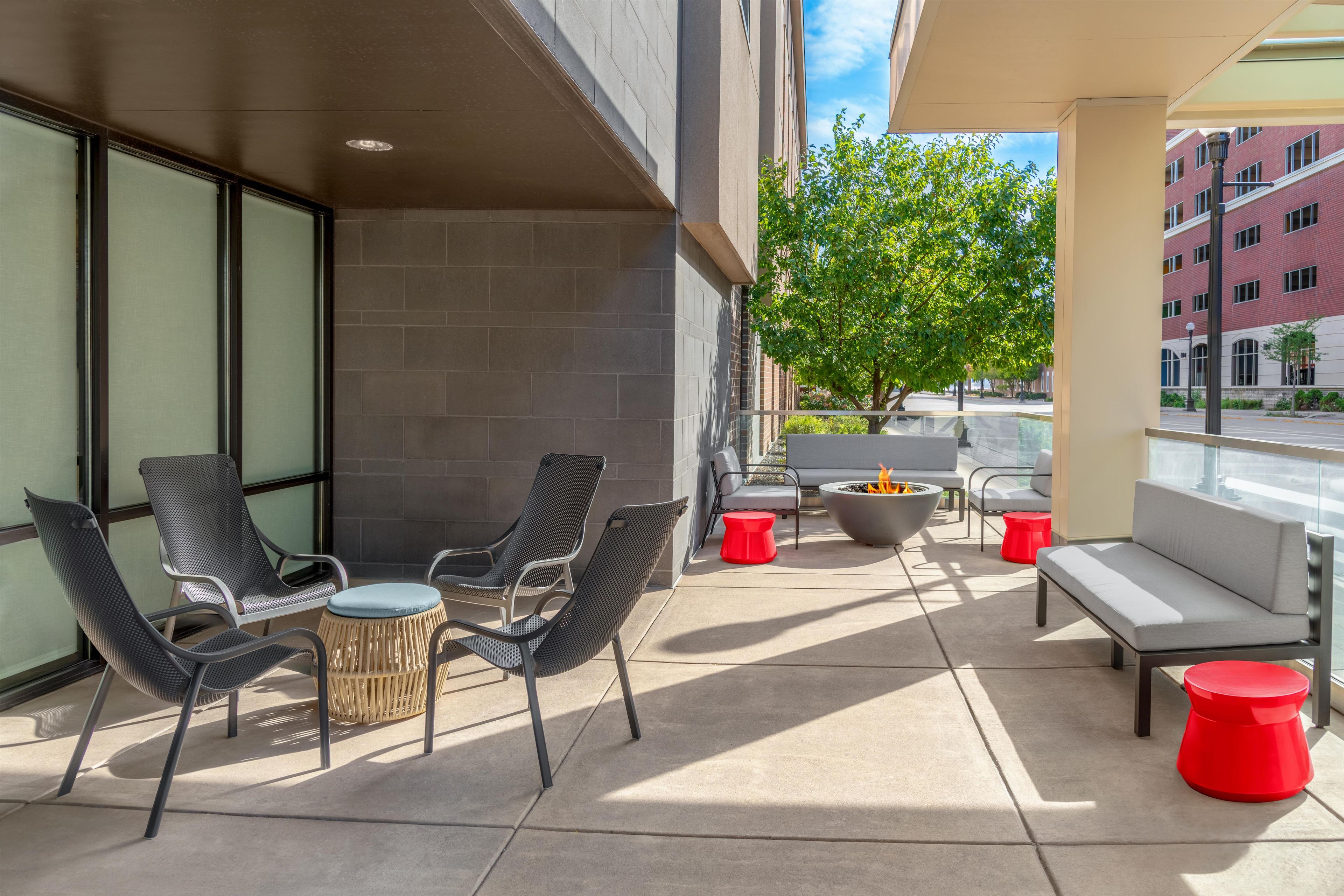 An outdoor seating area with chairs, a fire pit, and a view of the street.