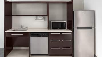 A compact kitchen with a dishwasher, microwave, and refrigerator.