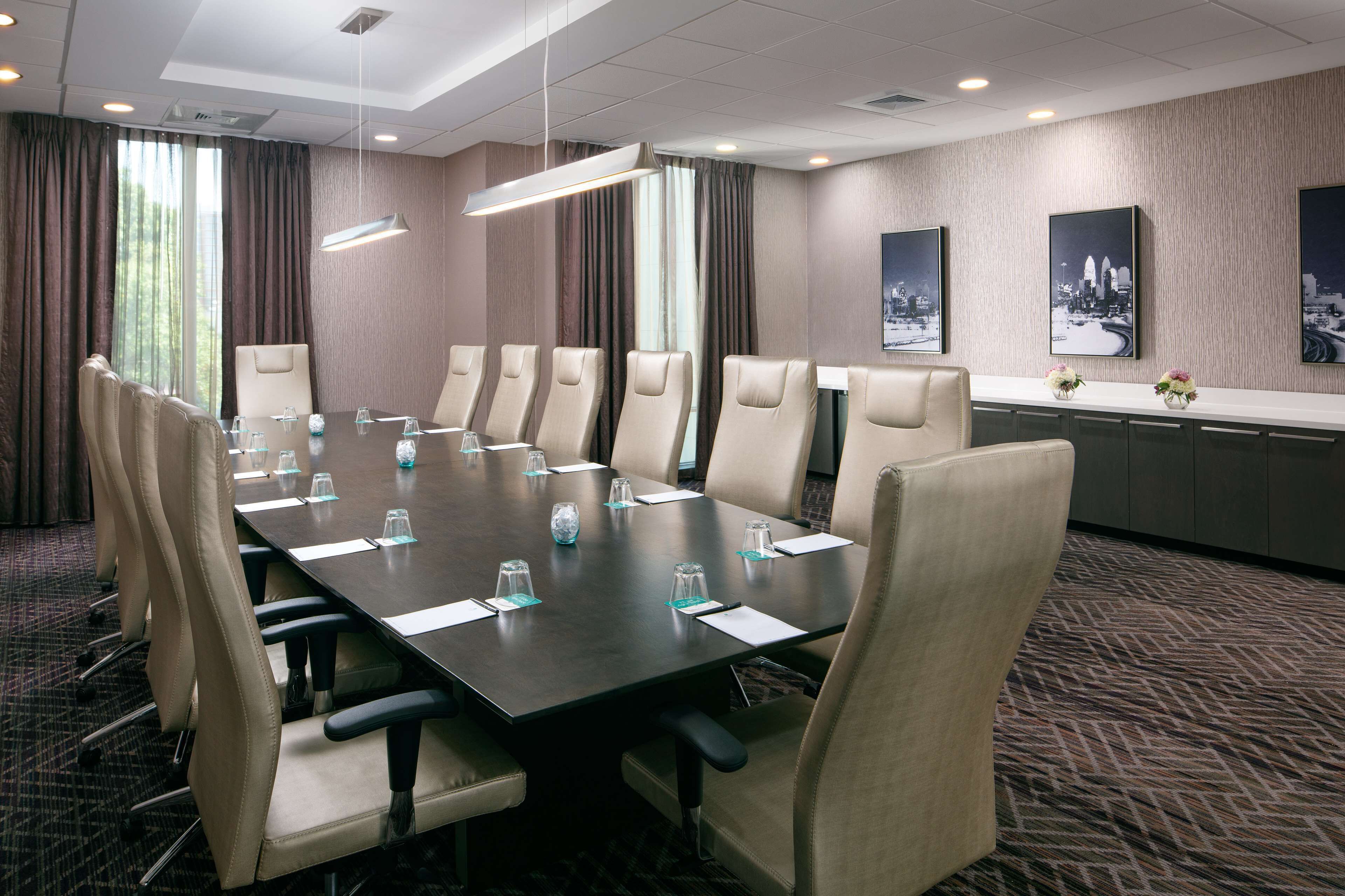 A conference room with a long table, multiple chairs, and a reception desk.