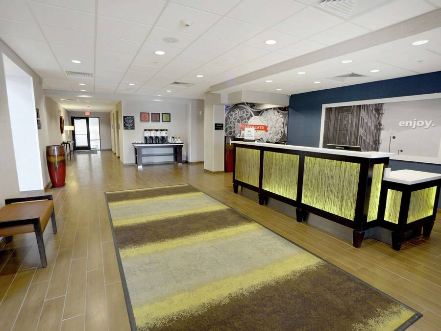 A reception area with a reception desk, a waiting area with benches, and a patterned carpet.