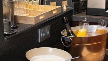 A kitchen with a stove, pots, pans, and a variety of glassware.