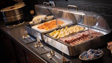 Een buffet met verschillende soorten eten en bestek.