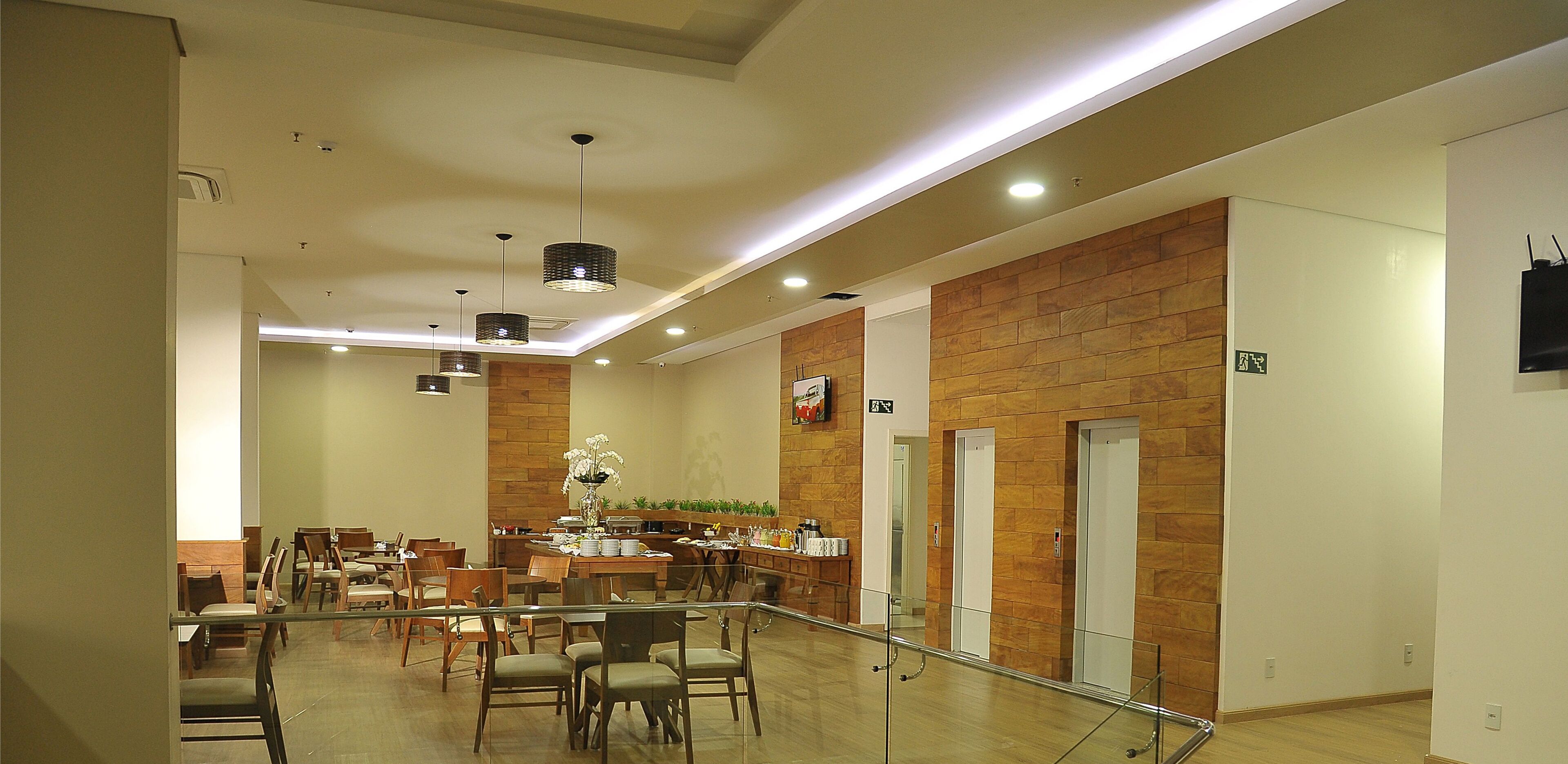 Un hall d’hôtel comprenant un espace repas, des murs en bois et un escalier.
