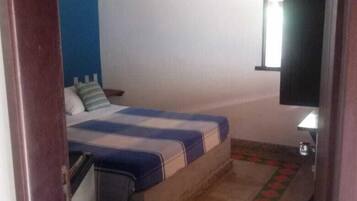 Een slaapkamer met een bed, een raam en een deur.