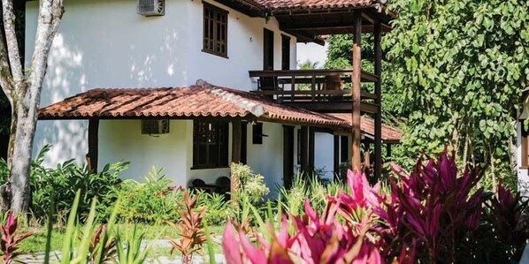 A two-story building with a tiled roof and a covered patio area. - Pousada Vila do Beco (Porto Seguro)