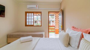 A bedroom with a bed, a bench, and a window. - Pousada ChaDay (Imbituba)