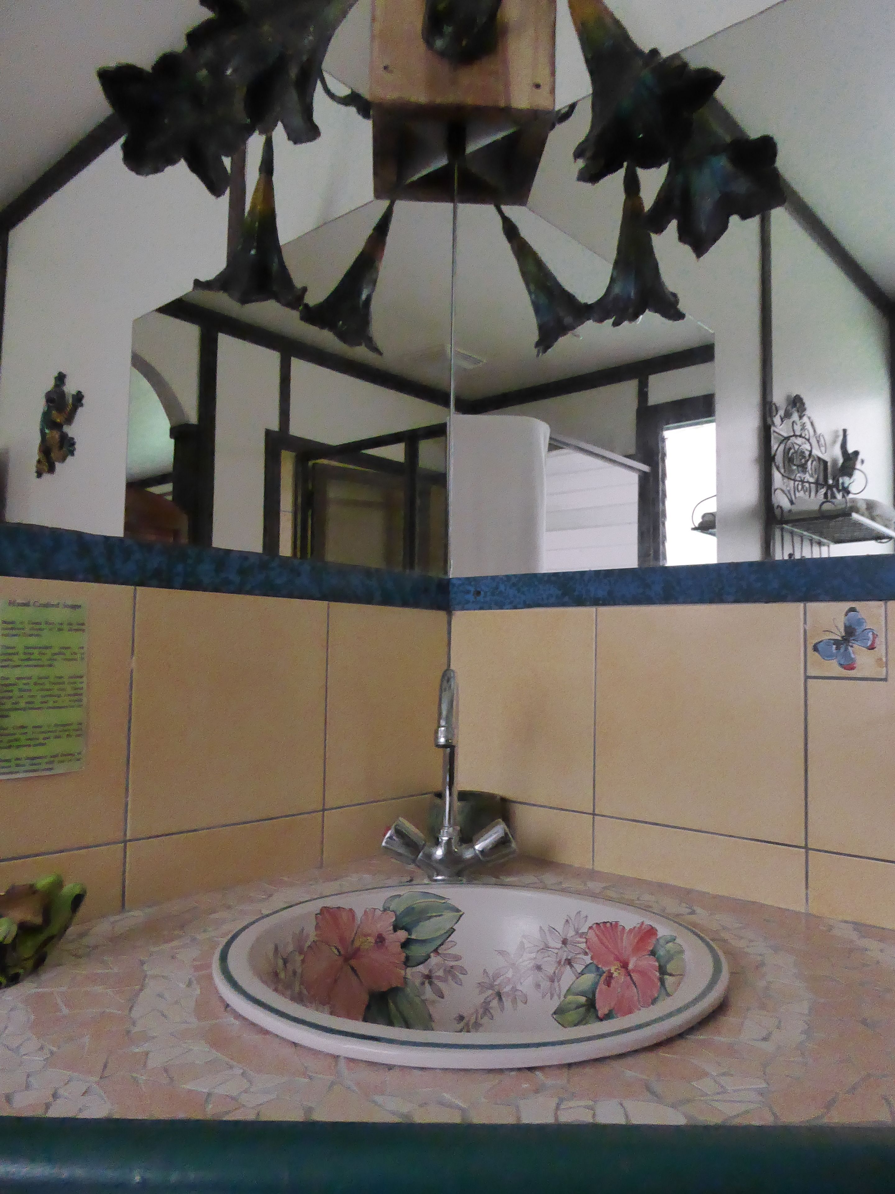 Een badkamer met een wastafel, een spiegel en een decoratieve hangende versiering.