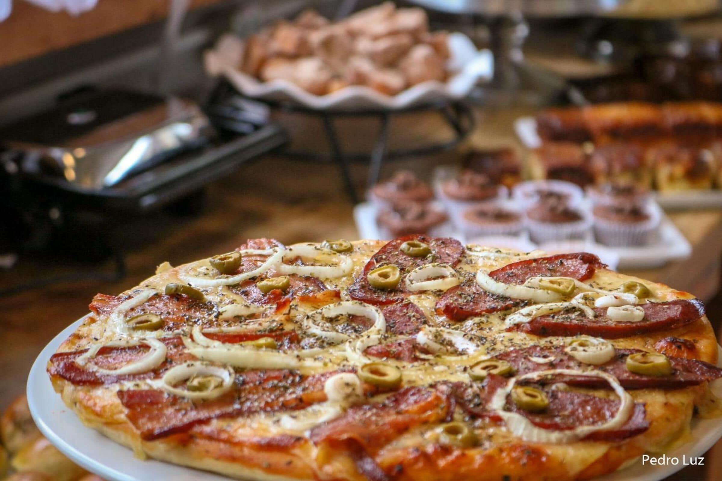 A pizza topped with pepperoni, olives, and onions.