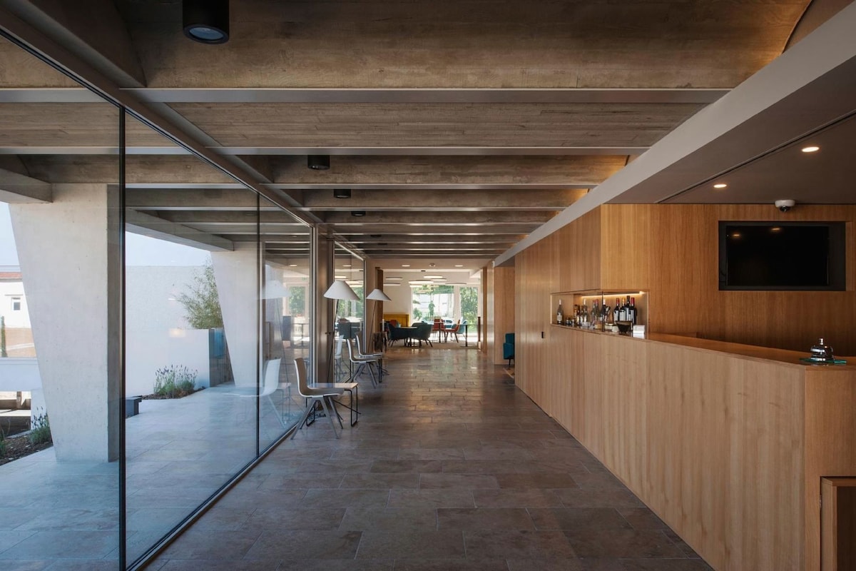 Ein modernes Interieur mit einer Rezeption, einer Sitzecke und großen Fenstern.