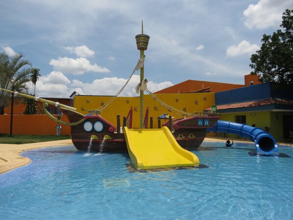 Un parque acuático con toboganes y una zona de juegos temática náutica.