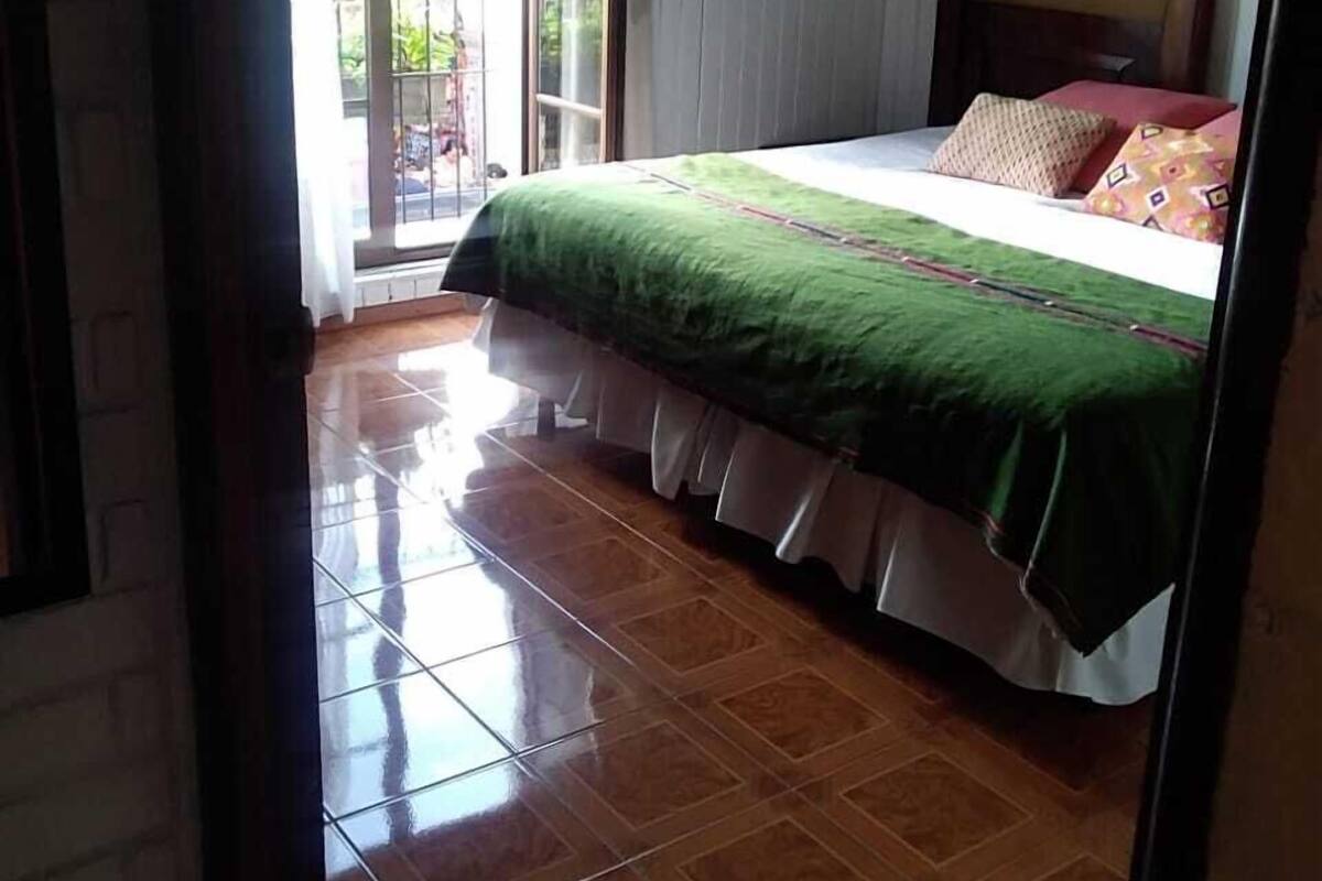 Een slaapkamer met een bed, een raam en uitzicht op buiten.