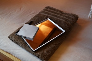 A laptop on a brown towel on a bed. - Lund house - Hostel (Kyoto)