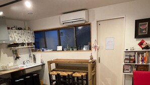 Un espacio habitable compacto con cocina, comedor y un pequeño rincón de estar con mesa de centro y sillas.