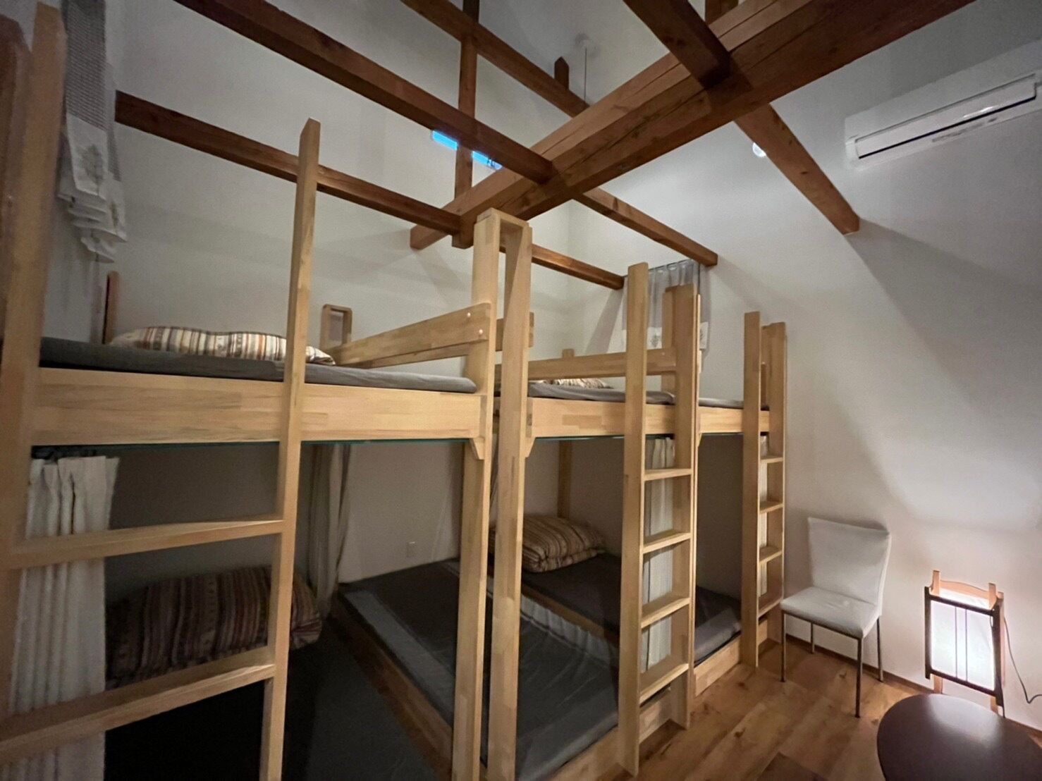 Un dormitorio con literas, una silla y una mesita.