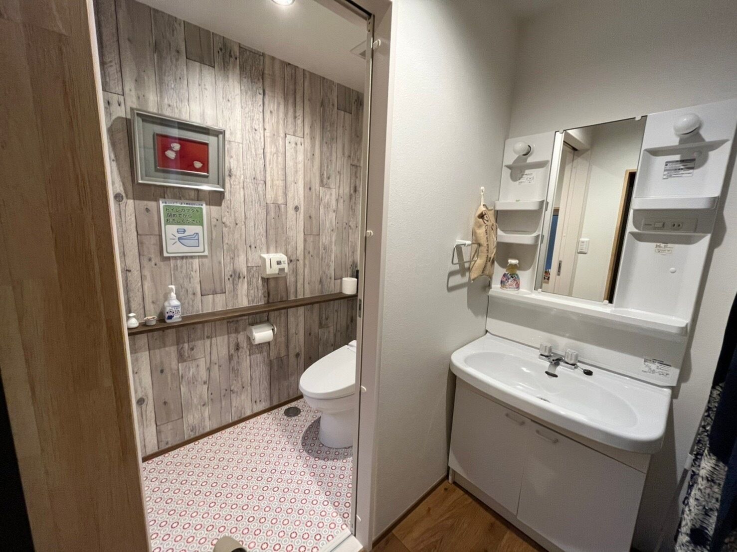 Une salle de bain avec un mur en bois, des toilettes, un lavabo et un miroir.
