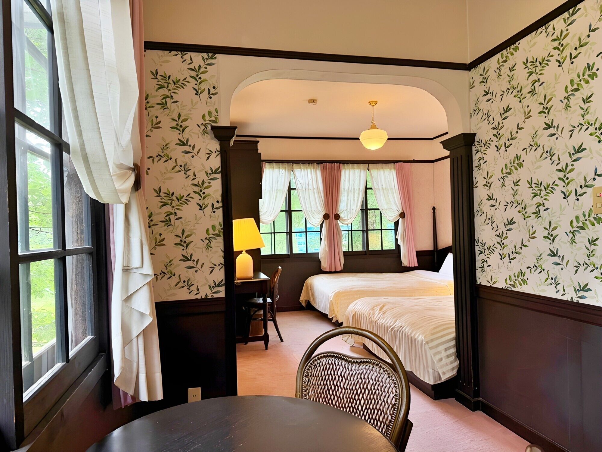 A room with a bed, a desk, a chair, and a table.