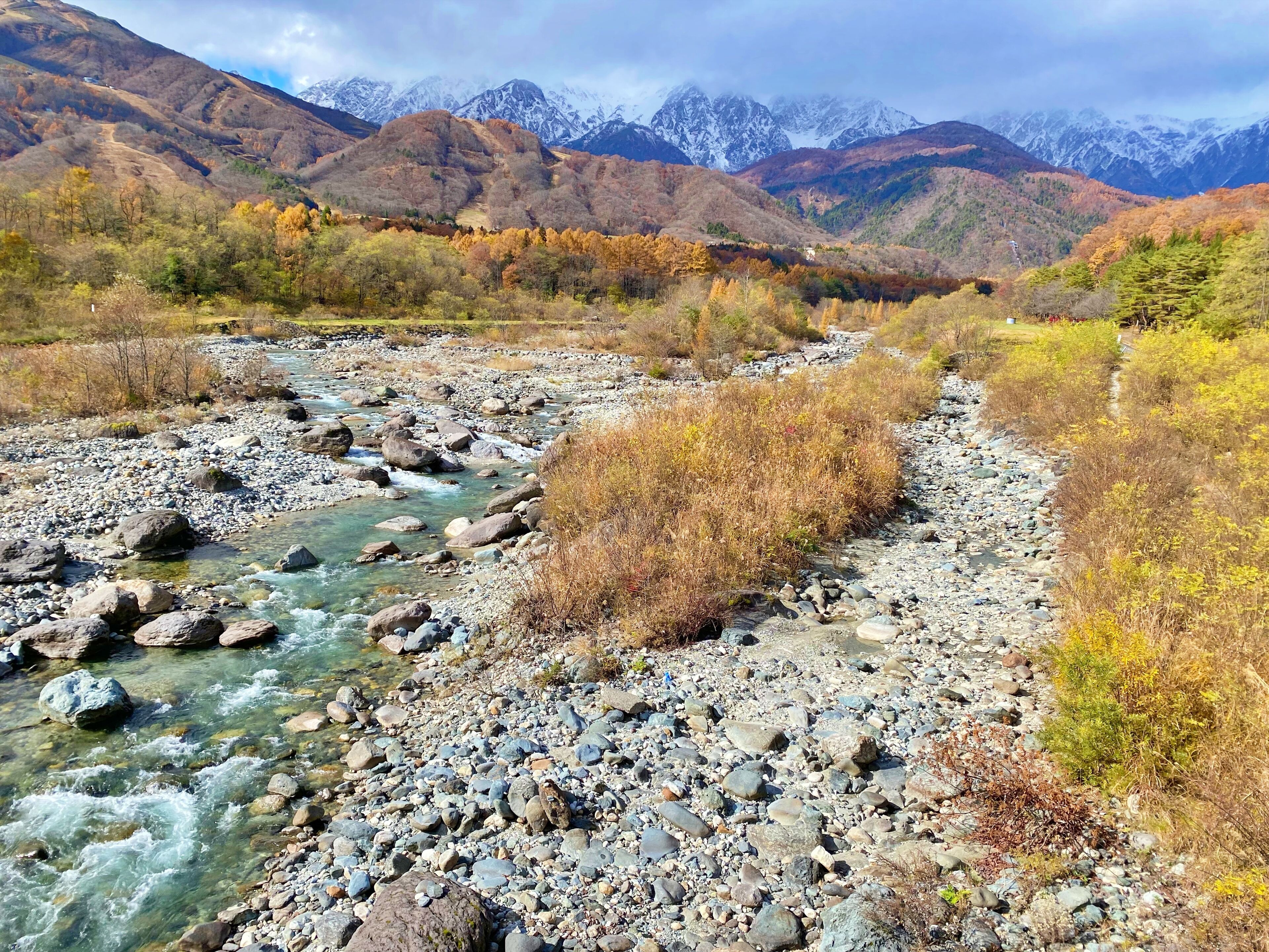 Un río que serpentea por un paisaje rocoso, con montañas al fondo.