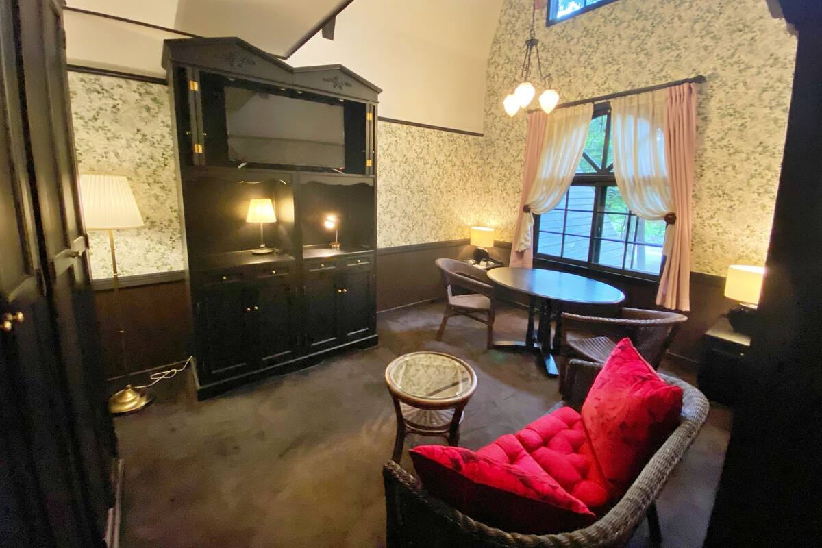 A cozy room with a dining table, chairs, a sofa, and a television.