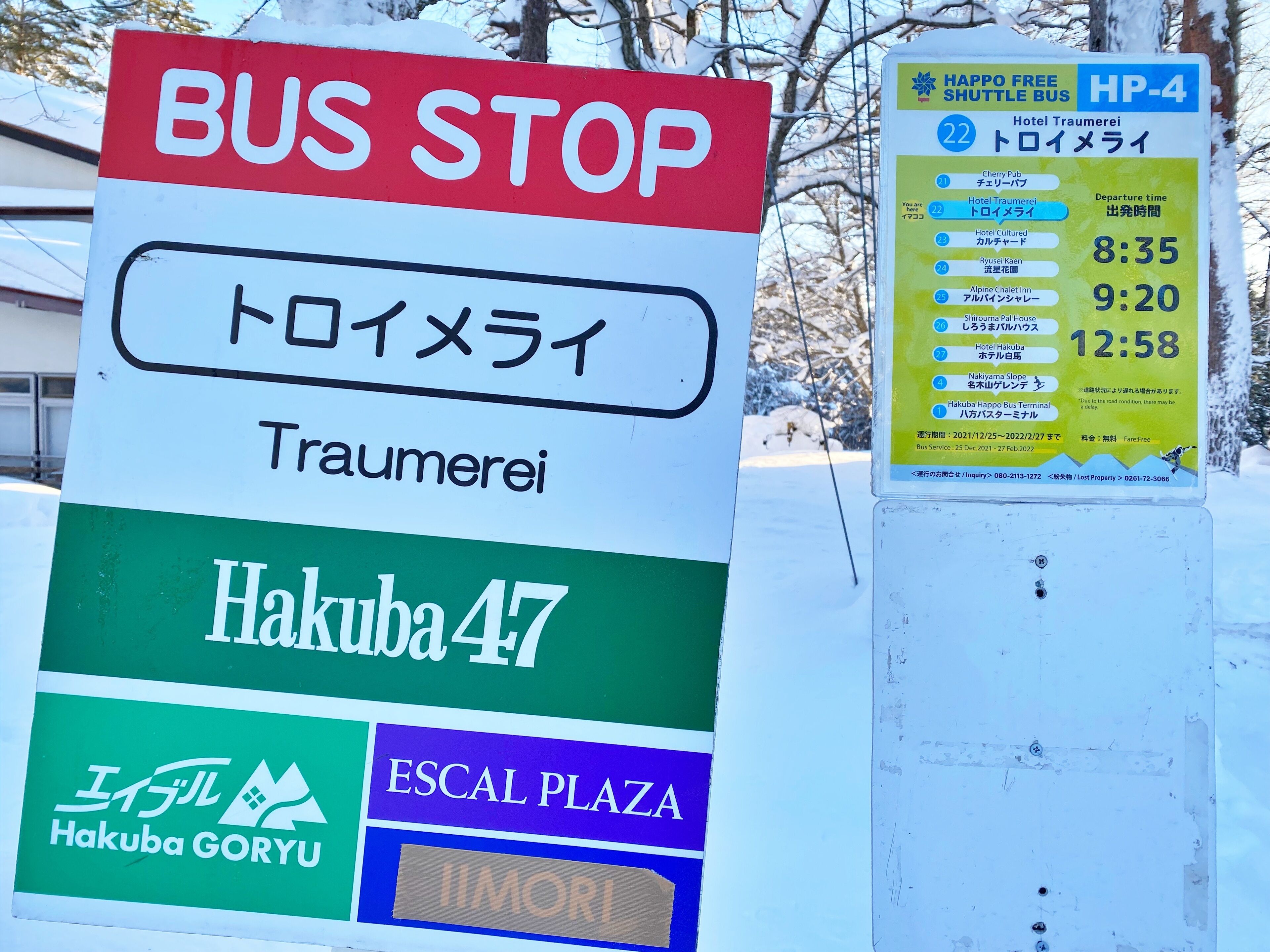 Et busstoppe skilt med flere destinationer og en køreplan for en shuttlebus.