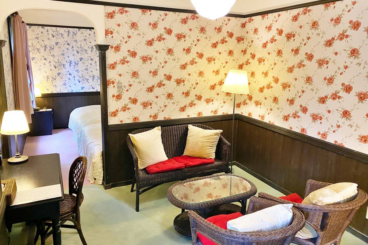 A hotel room with a corner seating area, a dining table, and a bed.