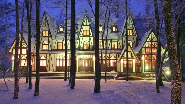 A large, multi-story house with a symmetrical facade, multiple windows, and a snow-covered ground. - Restaurant & Hotel Traumerei (Hakuba)
