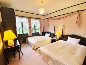 A hotel room with two beds, a desk, a chair, a lamp, and a window with curtains. - Restaurant & Hotel Traumerei (Hakuba)