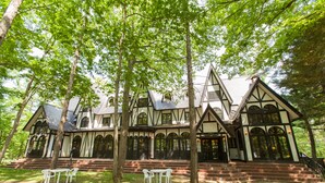 A traditional Tudor-style building with a steeply pitched roof, multiple chimneys, and a symmetrical facade with arched windows. - Restaurant & Hotel Traumerei (Hakuba)
