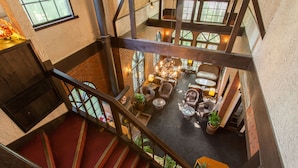 A spacious indoor area with a staircase, seating area, and a view of the upper floor. - Restaurant & Hotel Traumerei (Hakuba)