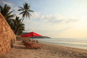 Perto da praia, espreguiçadeiras, guarda-sóis 