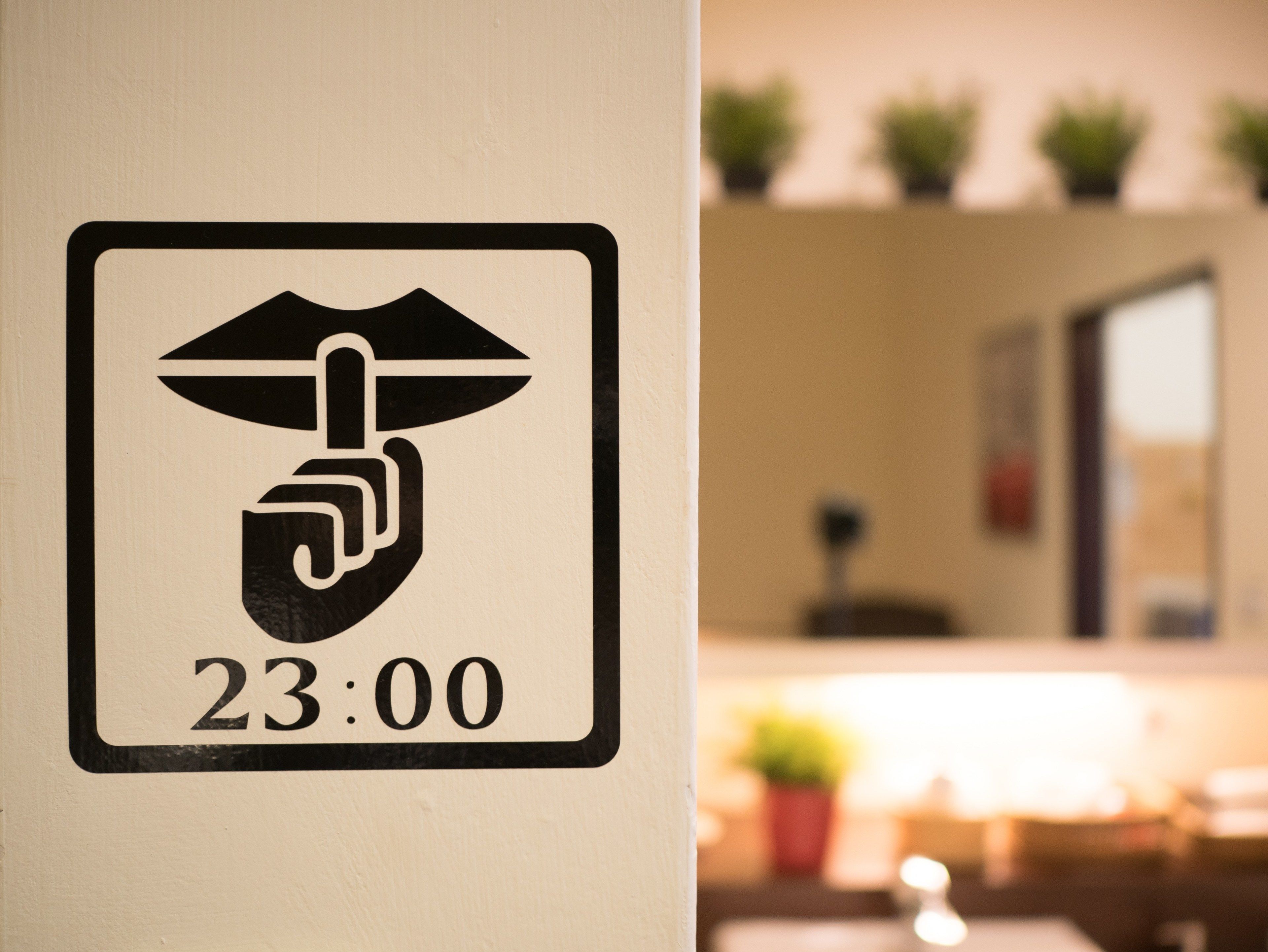 A sign with a hand symbol and the time 23:00, indicating a security or access point.