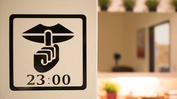 A sign with a hand symbol and the time 23:00, indicating a security or access point.