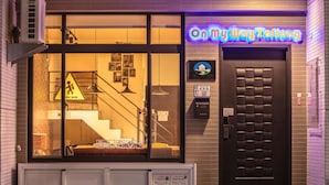 A building with a neon sign reading "On My Way Taifun" and a staircase leading to an upper floor. - On My Way Taitung Hostel Backpacker (Taitung)
