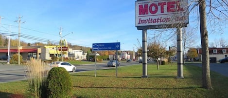 Un letrero de motel con una señal que indica el camino al Motel Invitation Inn.