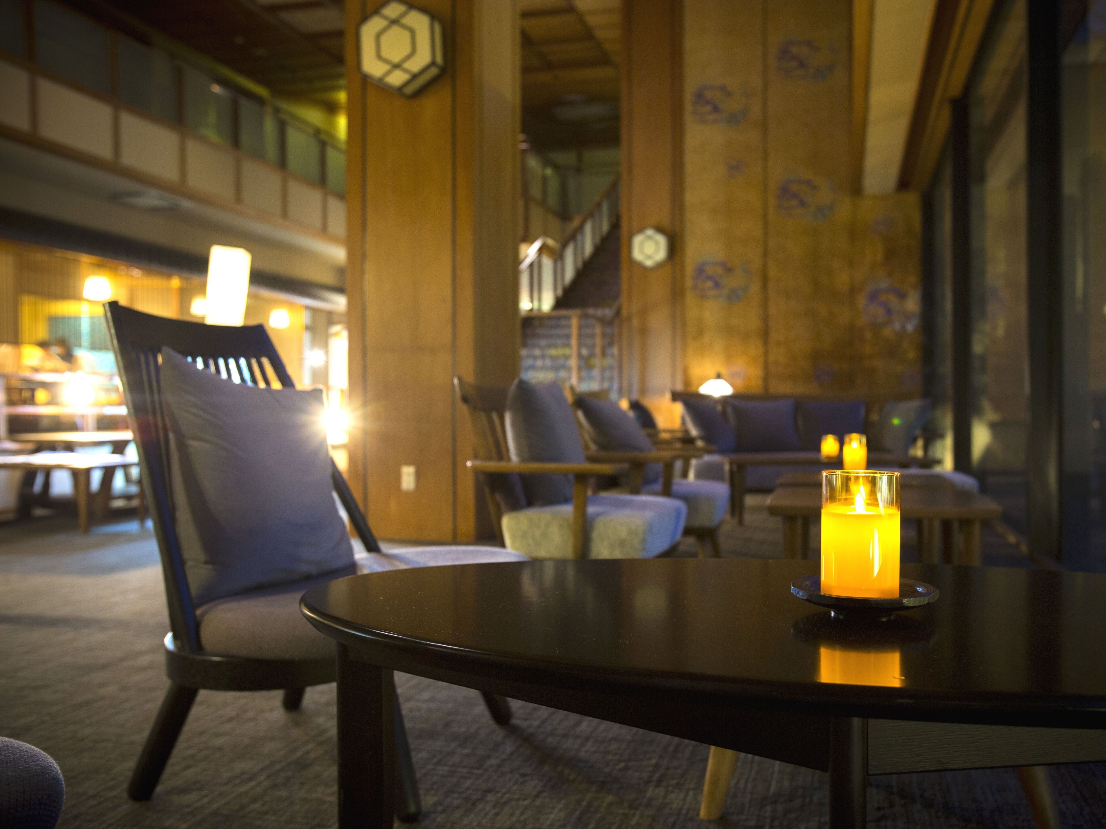 A cozy indoor seating area with a table, chairs, and a candle.