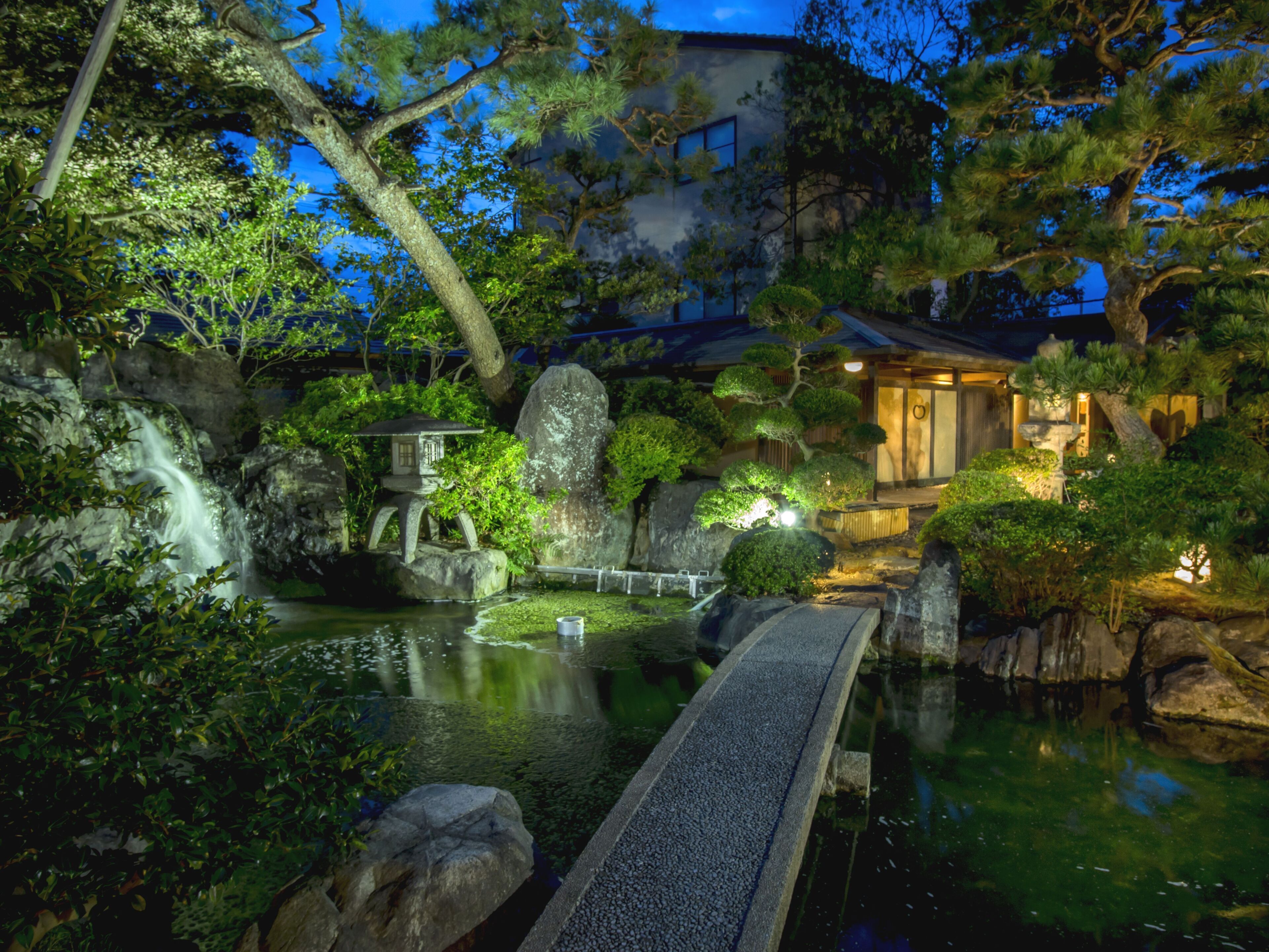 A traditional Japanese garden with a stone bridge, koi pond, and a waterfall.