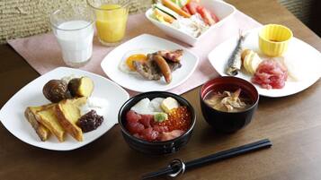 A table with various dishes including sushi, sashimi, and a bowl of soup.