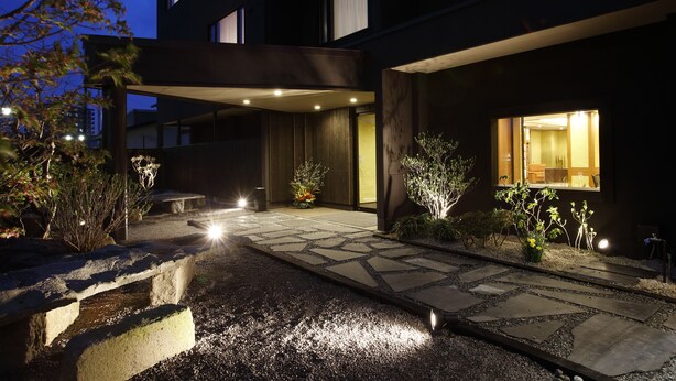 A modern building with a stone pathway leading to a covered entrance. - Yunokawa Onsen Emi Hakodateya (Hakodate)